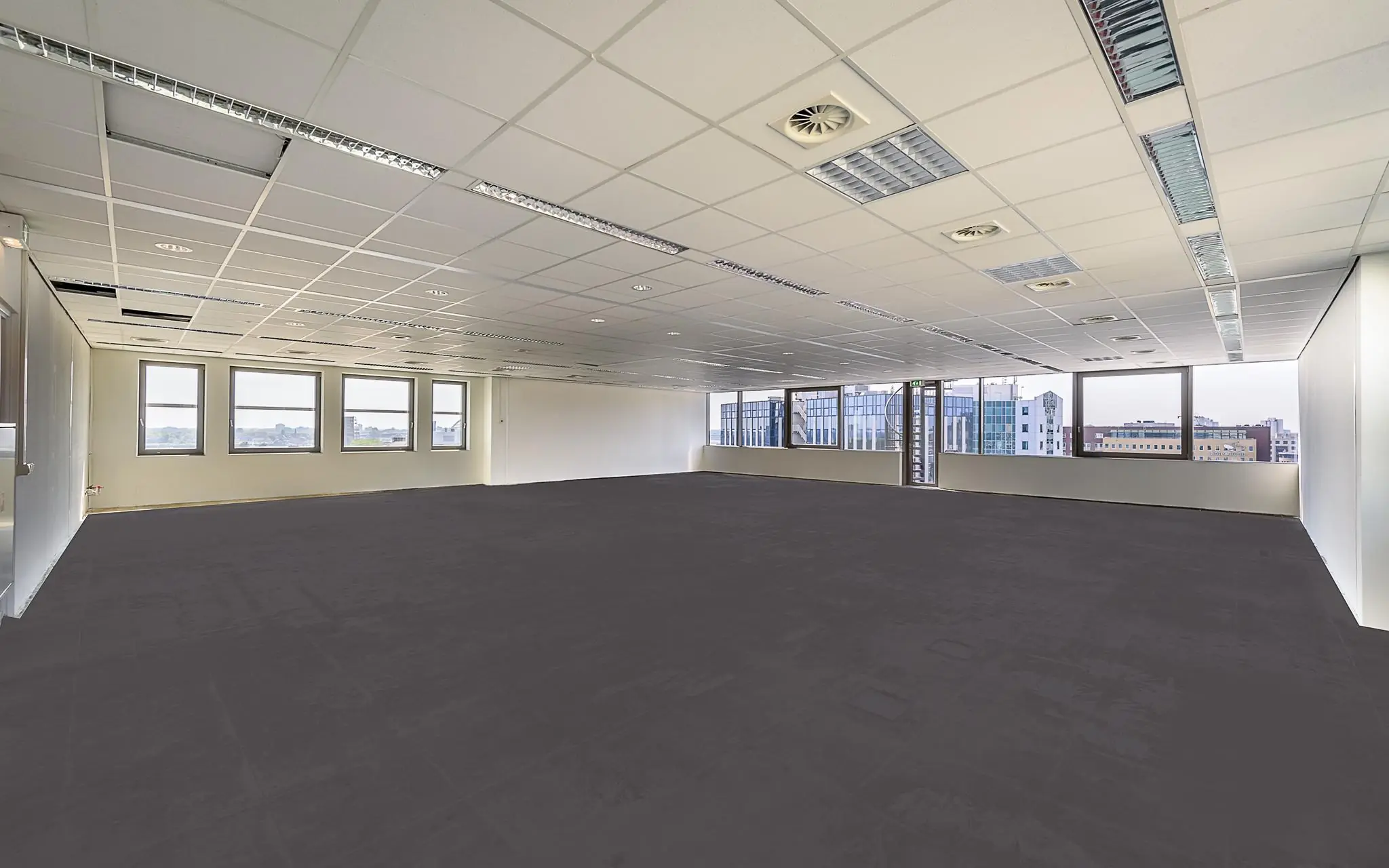 Leeg en modern kantoorpand aan de Rivium Boulevard met grote ramen en systeemplafond.